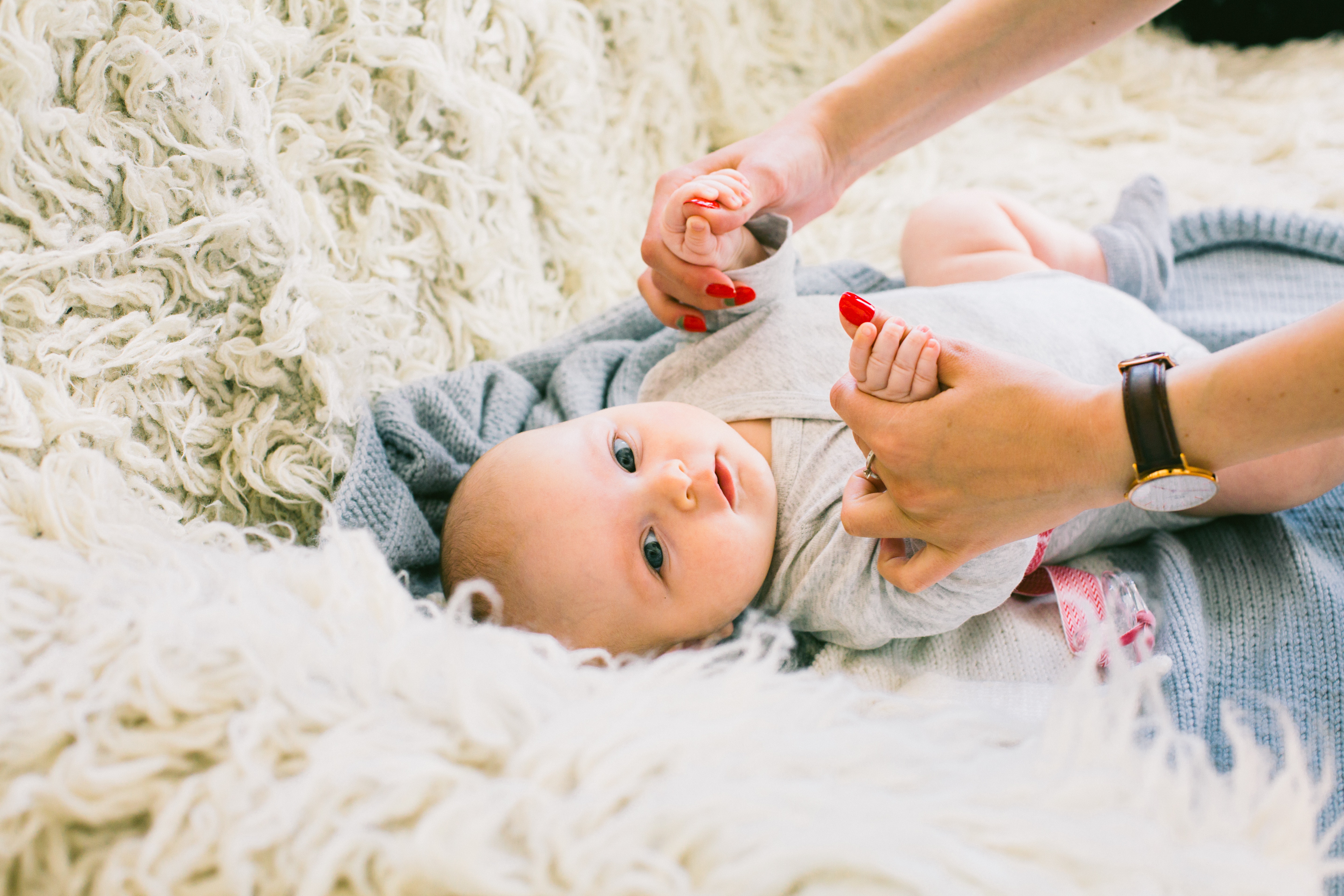 Baby laying on a wool fiber rug.